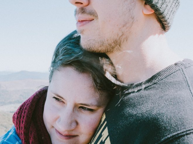 Couple looks off into distance on the top of a mountain in Western North Carolina