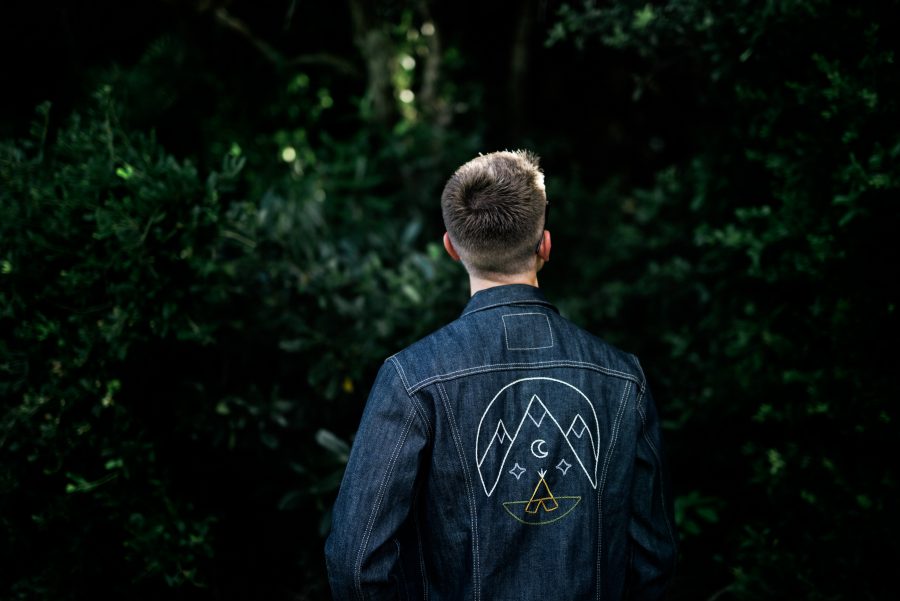 Young man wears custom embroidered jean jacket