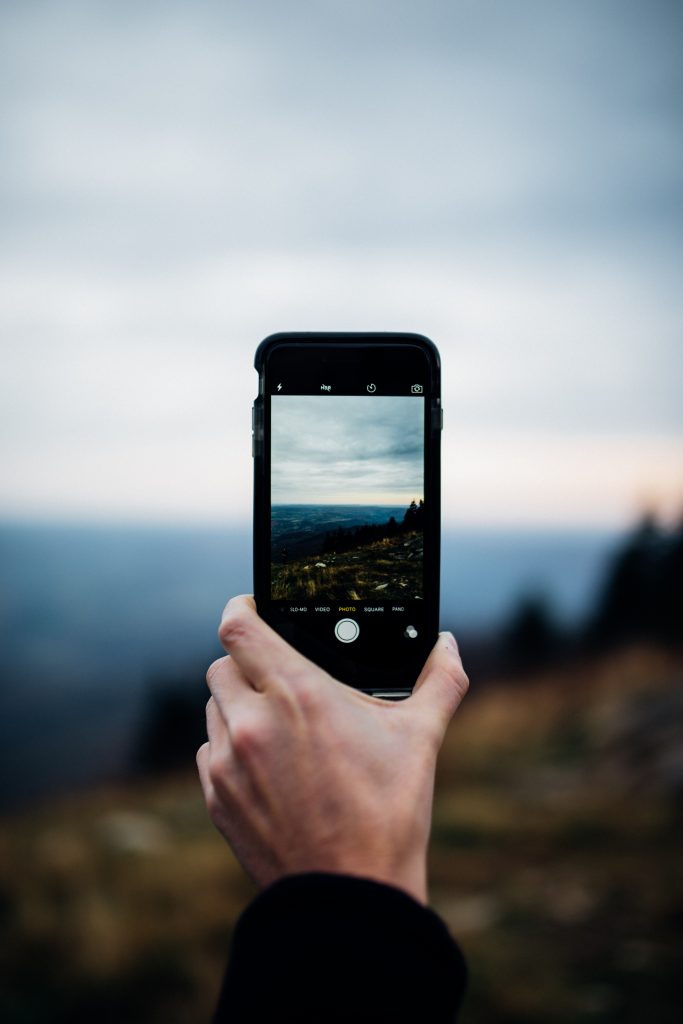 iPhone shows cloudy scene framed in viewfinder.