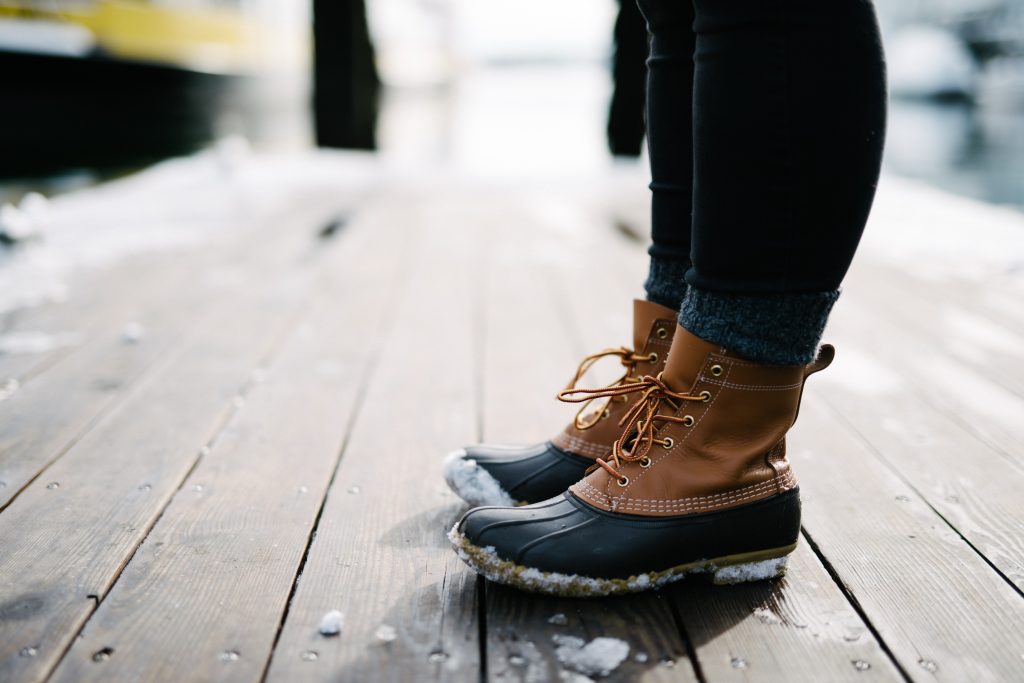 Snowy LL Bean boots in sharp focus on a floating dock in Portland Maine.