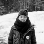 Young man bundled in winter clothes wears a Bernie Sanders pin.