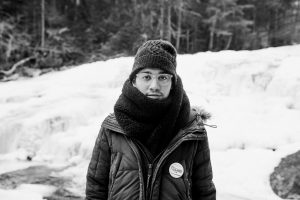 Young man bundled in winter clothes wears a Bernie Sanders pin.