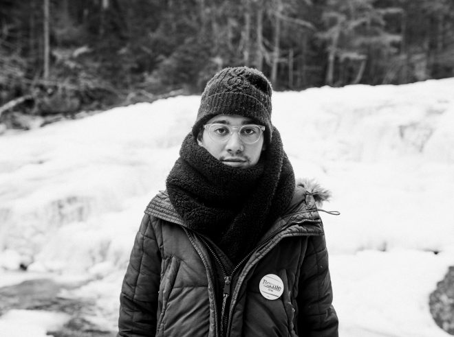 Young man bundled in winter clothes wears a Bernie Sanders pin.