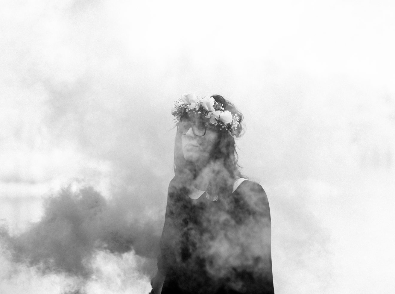 Danielle stands in front of a lake with smoke all around her.