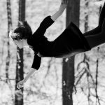 Woman dressed as Wednesday Addams appears to be floating, or falling, from the top of the frame.