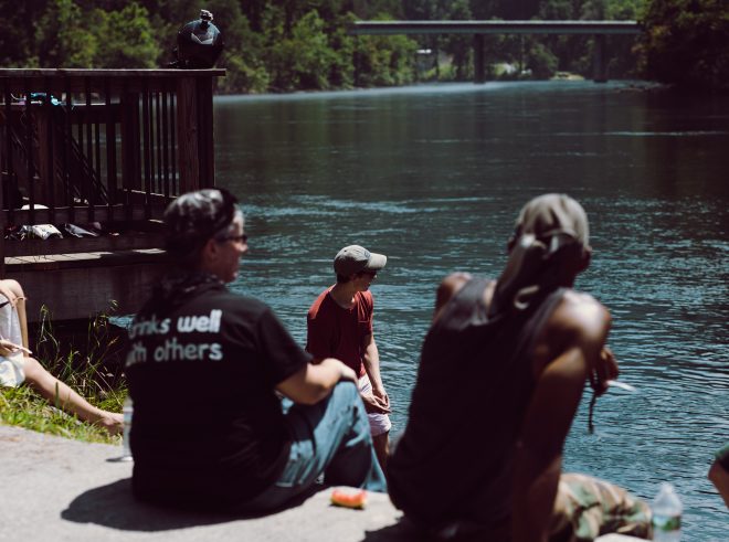 Ford can be seen between two new friends skipping rocks across the river.